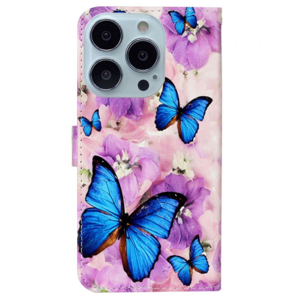 Kožený Kryt iPhone 16 Pro Modrí Motýli A Fialové Květiny S Popruhem